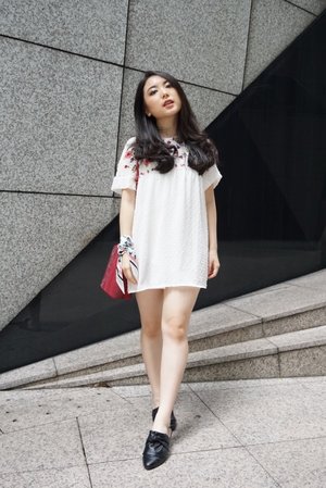 City wandering in a cute mini white dress with floral embroideries completed with a statement red sling bag and black tied-knot mules. Styled it with a twist of twilly scarf wrapped around the wrist into a bracelet. 