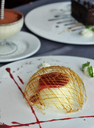 Smooth vanilla milk pudding served with a caramelized sugar dome and raspberry sauce #ValentinoJakarta