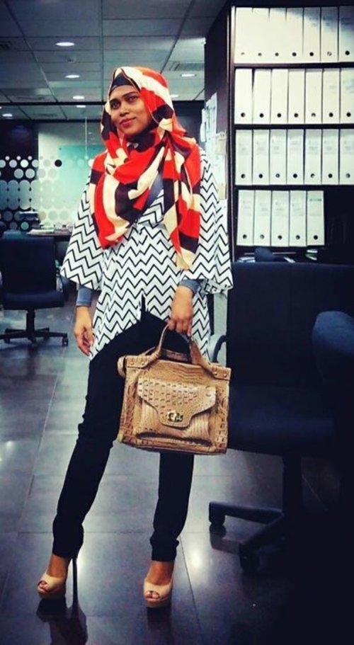 Grey long-sleeve shirt, black-and-white kimono outer with tribal motive, red-black-white hijab with abstract motive and black trousers