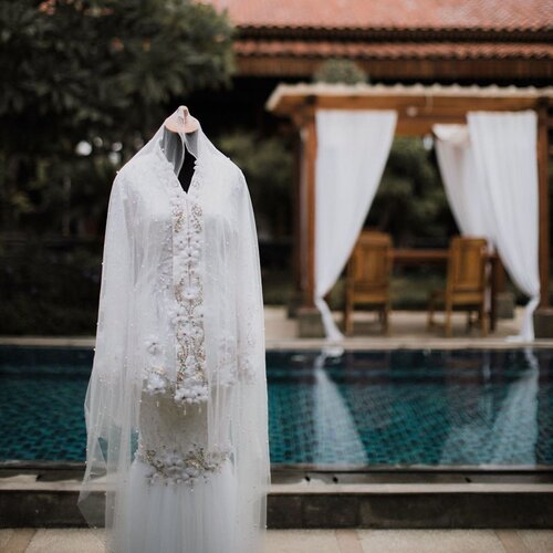 Selecting a wedding dress is more than just a fitting.... It's process - a memory in the making -OCJ-Niatnya mau sewa aja buat wedding dress aku.. Tapi liat biaya sewa kok kayanya sayang banget uang segitu gede buat nyewa baju doang wkwkwkwkw *maklum pengantennya PUWEEELIIIT* Dan rata2 wedding dress yg aku mau yang simple2 itu harga sewanya lebih mehong dari yang ribet n rame 😅😅 akhirnya dengan berbagai pertimbangan, kuputuskan untuk buat wedding dress sendiri, yg sesuai sama mau aku. Yang simple ga ribet tapi tetep cantik n anggun.. Dan biayanya jauh lebih murah dr aku sewa PLUS bajunya jadi hak milik 🤑🙃 Seperti yang kalian ketahui bahwa aku mengurus semua keperluan pernikahanku ini sendiri. Jadi every detail dari bahan2nya aku yang pergi dan cari sendiri, bahkan beads yang terpasang dan beli dimana aku ikut mikirin. Dan semuanya ini ga mungkin terwujud tanpa tangan berbakat @risnayustiani , my wedding dress maker 💕 sempet ada drama diawal pembuatan krn tetiba Risna mau quit from this job bcause she's pregnant.. Tapi akhirnya ga jadi karena satu dan lain hal 😘😘 Aku gapernah dibuat kecewa sama Risna dari awal aku buat horden wkwkwkwwkwk trus baju lamaran dan sampai pada akhirnya 2baju pernikahanku. Untuk akad dress aku pengen pake baju kurung melayu. Kenapa ? Karena aku suka kesimple an baju pengantin melayu saat menikah. Dan aku pengen banget pake salah satu koleksinya @iam_inderaloka , tapi sayang jauh yaa booo'.. aku bukan anak sultan juga 🤣 jadi aku ambil inspirasi wedding dress aku dr sana. Terus biar ga menghilangkan ciri khas Indonya, aku pengen atasannya ala2 kebaya kutubaru gt. Aku gamau buat baju yang ribet karena aku pengen memudahkan dress maker aku juga.Baju kedua adalah baju ide2an kita berdua. Karena aku ga mau ganti baju sampe 3x.. akhirnya aku sama Risna buat Party Dress yang lain dari biasanya 🤣🤣🤣 kita buat 2 looks dalam satu baju.. And it works guys~ untuk foto yang kalian lihat itu adalah 1st look dr dressnya yang aku gunakan saat Wedding Enterance.. Dan 2nd look itu aku gunakan khusus diatas pelaminan 😍🥰😘#VannyGotAPie #RoadTWOtheAisle Attire @byvannisa x @risnayustiani Venue by @pendopo_andaru ..#clozetteid