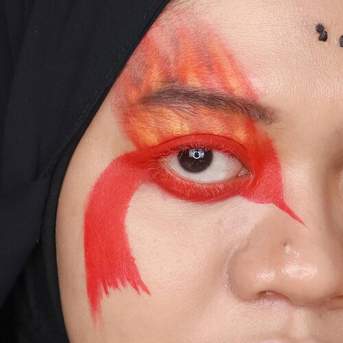 Sekilas detail makeup Hunger Games - District 12 kemarin. Seperti yg aku bilang di post sebelumnya, inspirasinya dari Mockingjay dan skill melukis realis Peeta yg menggambarkan batu bara menyala sebagai identitas Distrik 12.

Sengaja dominan pakai warna merah, orange, kuning dan efek batu bara menyala yg mengisyaratkan jiwa mereka memberontak sewaktu diikutkan Hunger Games. Nggak menghilangkan unsur makeup “nyentrik” warga Panem, aku pakai eyeliner gold dan lipstik nude metalik kehijauan supaya keliatan unik. Kalau di-zoom gini keliatan kan ribetnya makeup ini, terutama nempelin kerikilnya satu per satu 😂. Tapi seriusan sih jadi ketagihan makeup nantang lagi 😁.

Products used:
@poppydharsonocosmetics Lip Cream Crimson Red
@beautyglazed Color Fusion
@handaiyanbeauty Mascara White
@focallurebeauty Palette Bright Lux
@makeoverid Eyeliner Pencil Glam Gold 
@lagirlindonesia Glitter Magic Champagne Fizz

#hungergamescollab #hungergamesmakeupcollab
#district12 #Mining #district12makeup #hungergamesmakeup #miningmakeup #coalmakeup #sfxmakeup #sfx #makeup #beauty #beautyinfluencerindo #fakeupfix #indobeautygram #clozetteid