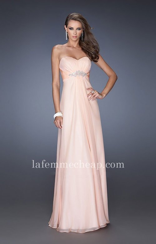 This La Femme 19759 gown is a classic! The strapless sweetheart bodice is gathered for a glamorous look. Cinched at the empire waist with a shimmering tonal ribbon and twinkling crystal brooch, this elegant ensemble glides to the full-length A-line silhouette hem with grace. This dress is perfect as a Homecoming Dress, Wedding Guest Dress, Prom Dress, or a Special Occasion Dress. Size: Standard Size or Custom Made SizeClosure: Back ZipperDetails: Ruching Bodice, AppliqueFabric: ChiffonLength: LongNeckline: Strapless SweetheartWaistline: EmpireColor: ApricotTag: Apricot, Long, Strapless, Prom Dresses, La Femme 19759