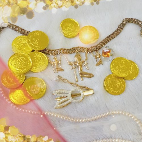 Props for my Hunger Games District 1 collab, i just piled on my chunky gold accessories haha.

The chocolate gold coins idea came from @hincelois_jj and when i get an idea that i like, i just can't let it go so i actually whined at my husband until he took me to a supermarket after work to grab some old skool gold coin chocolates. I originally thought that i could buy a packet with 20 or less coins inside, but alas... There was only big jars of them and my husband would smack me if i bail so... I got one even though i don't even like chocolate and i would nibble one or two whenever i need something sweet so i still got most of them by now 🤣.

Anyway!

Fun fact : i used to hate gold and go for white gold but now i actually prefer gold! What's going on?

#clozetteid #gold #luxury #hungergamescollab #district1 #BeauteFemmeCommunity #golden  #thematiclook #props 
#sbybeautyblogger #clozetteid #sbybeautyblogger #hungergamesinspired #goldcoins #bloggerceria
#beautynesiamember #bloggerperempuan #indonesianfemalebloggers  #bblogger #bbloggerid #influencer #influencersurabaya #influencerindonesia #beautyinfluencer #surabayainfluencer #jakartabeautyblogger #SURABAYABEAUTYBLOGGER #beautysocietyid